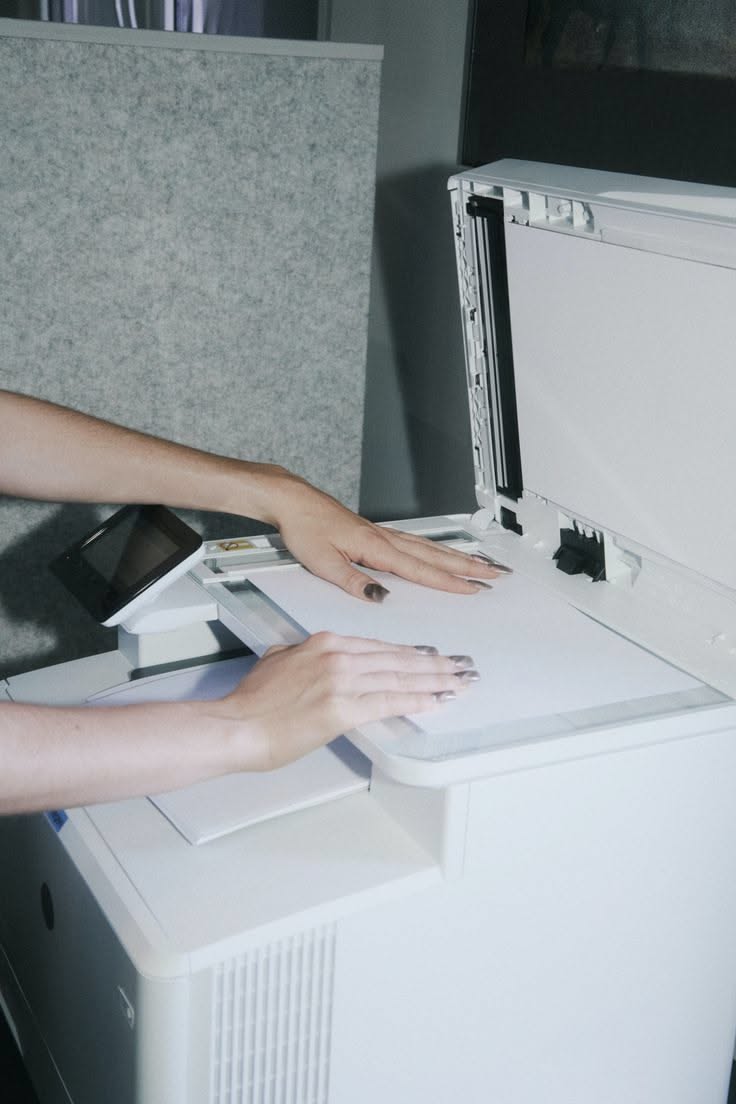 Hands working with an office printer