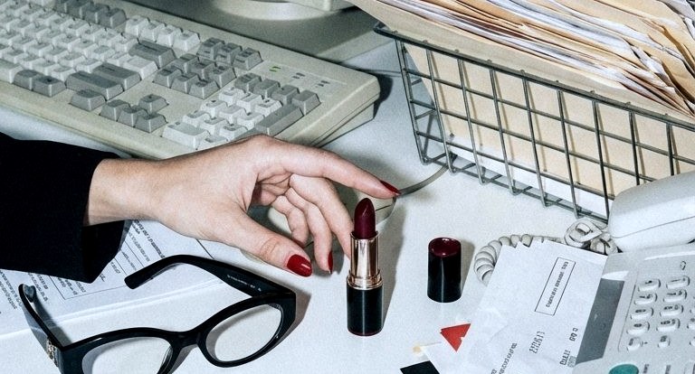 A hand arranging small objects beside an office keyboard